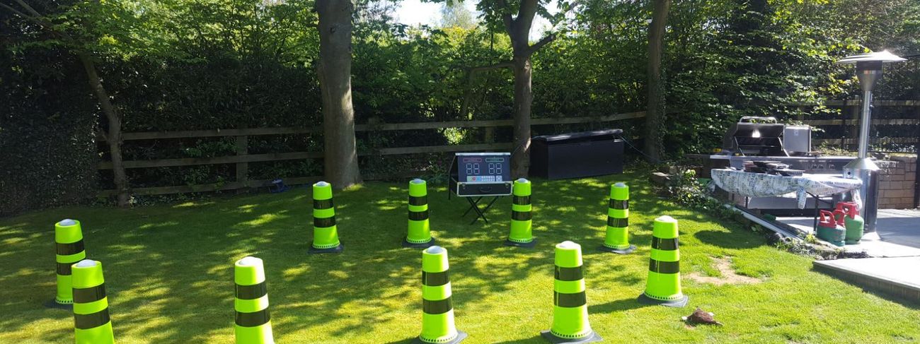 IPS Podium Challenge - ten neon green wireless cones arranged across a garden lawn with digital scoreboard unit