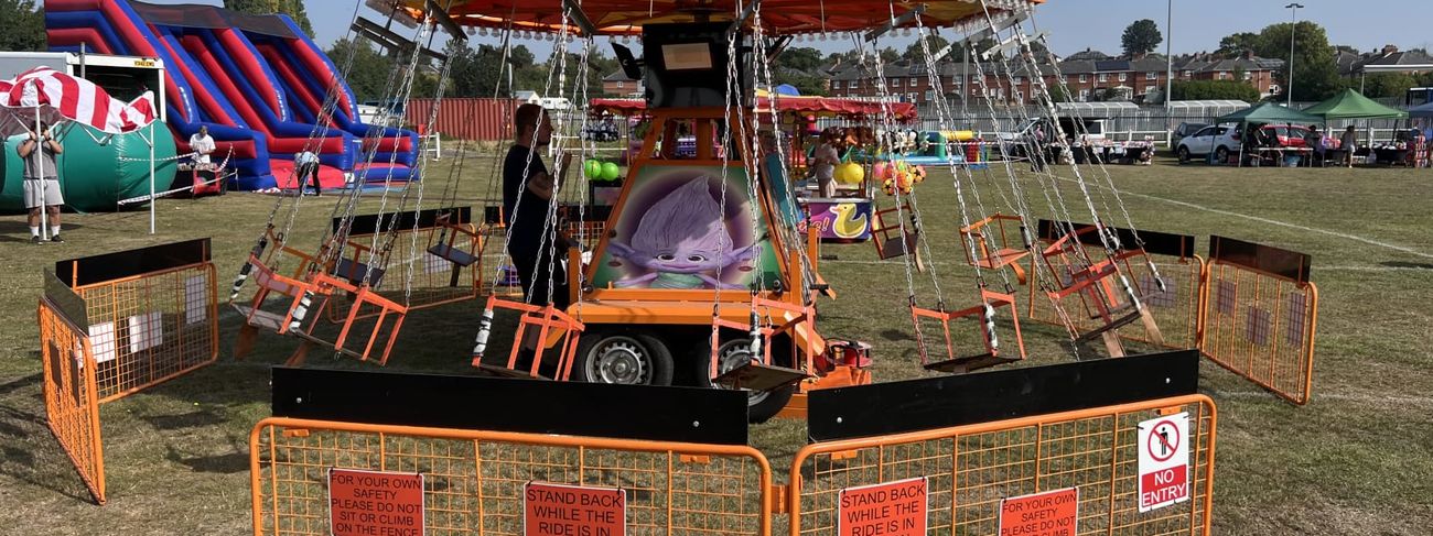 Orange carousel set up at sunny outdoor fairground