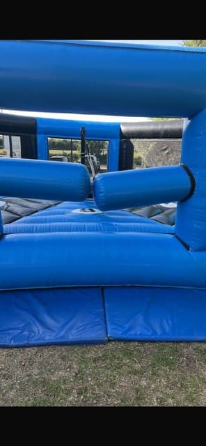 Sweeper arm passing over a numbered player podium inside the walled inflatable arena