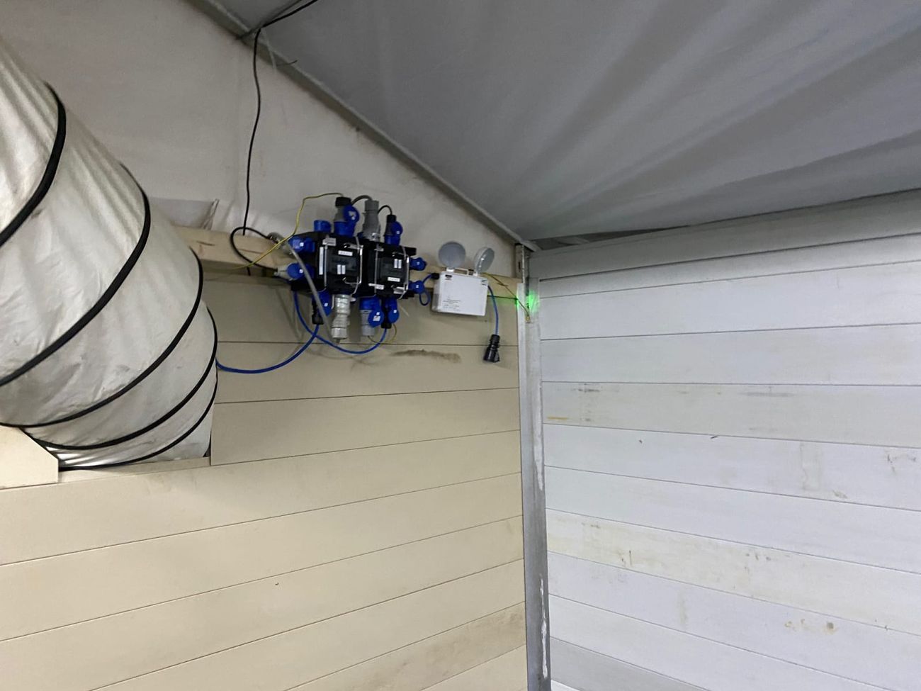 Emergency flood lights mounted at the apex of a marquee beside a power distribution unit