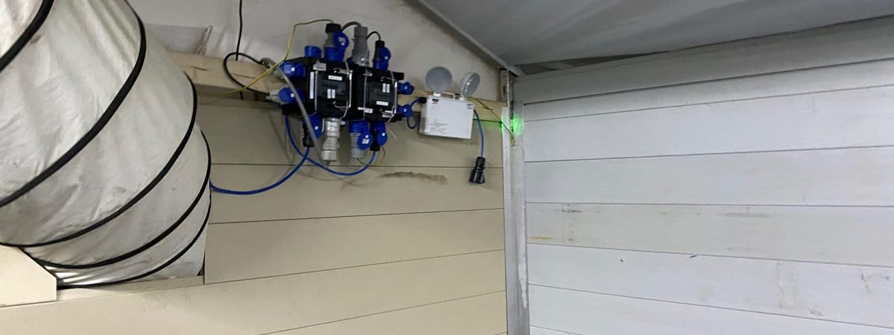 Emergency flood lights mounted at the apex of a marquee beside a power distribution unit