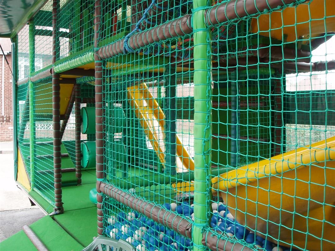 Inside the three-level play bus - padded posts, safety netting, twin slides and the blue and white ball pool