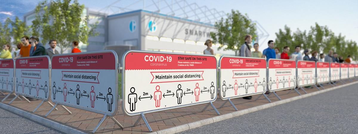 Barriers with COVID-19 social distancing signage outside venue