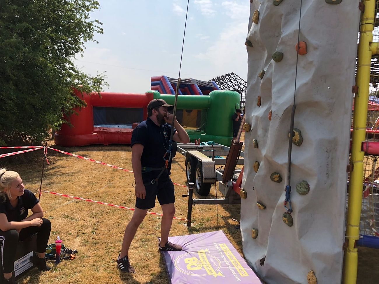 Our crew preparing the mobile climbing wall with harnesses and mats at the base