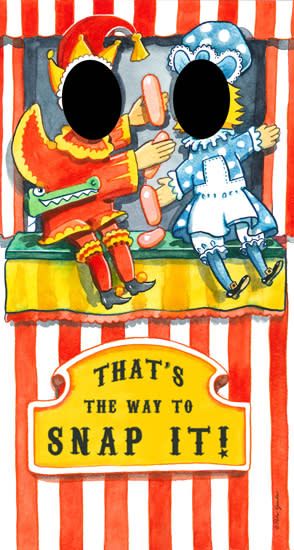Painted face-in-the-hole board showing Punch in red with a hooked nose and yellow tassel cap, and Judy in blue polka dots, on a striped puppet stage with a crocodile and pink sausages between them