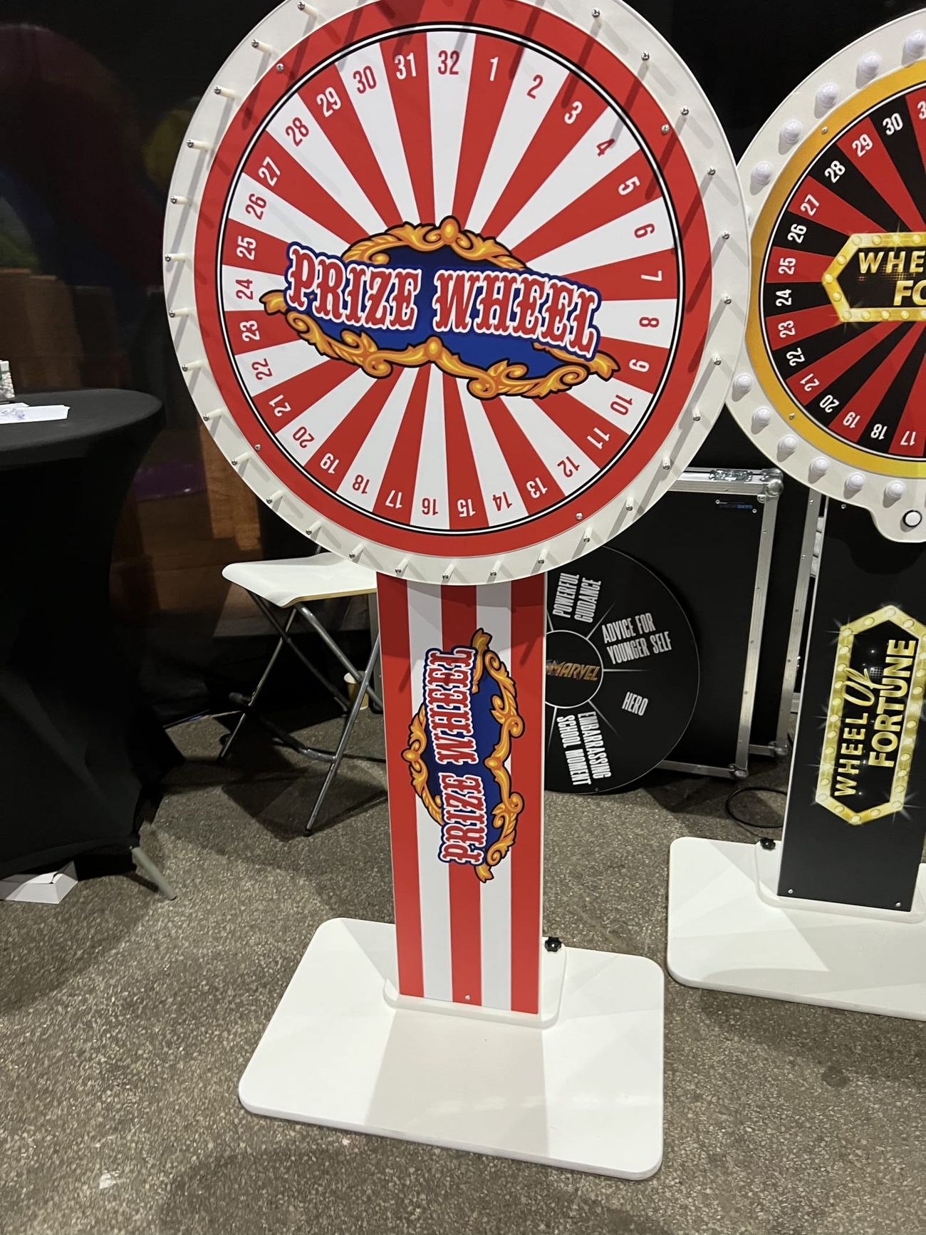 Prize Wheel on a striped pillar base alongside a Wheel of Fortune unit