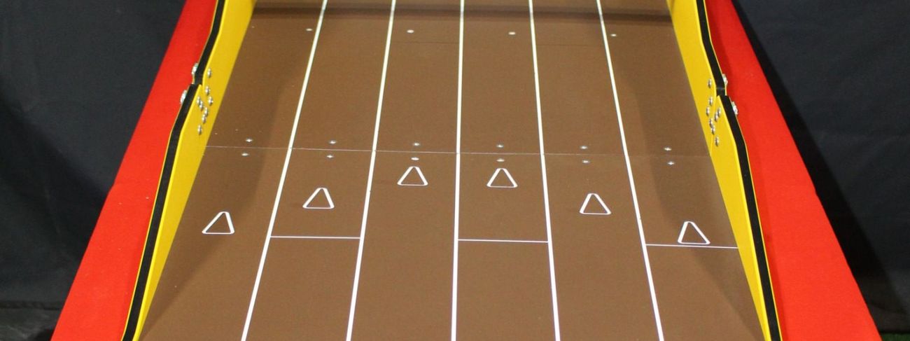 The full Strike Zone table-bowling lane with three pucks at the near end and the pins set on the flip rack