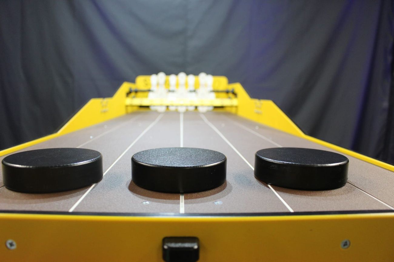 Low-angle close-up of the three Strike Zone pucks with skittles in the background