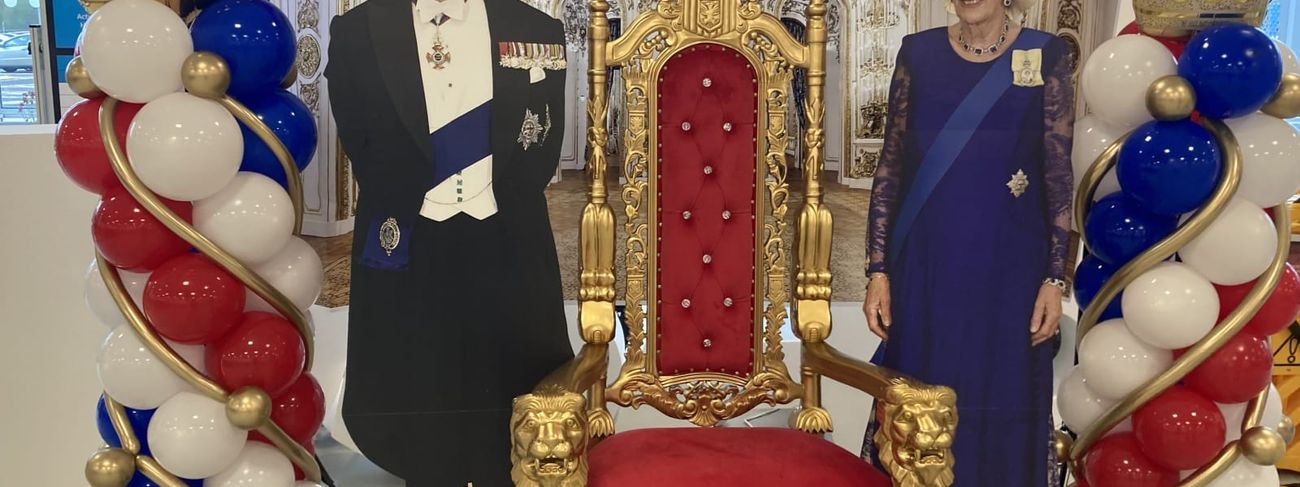 Single gold throne dressed as a royal photo set with crown balloon columns and a red drape