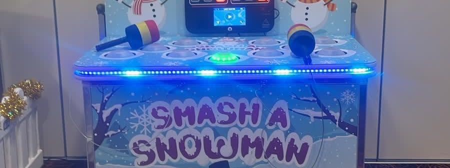 Whack a Snowman arcade cabinet with snowman backboard graphics, digital scoreboard and foam mallets