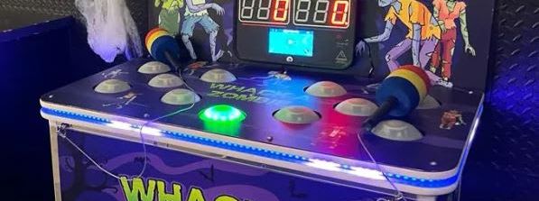 Whack a Zombie bench-top arcade cabinet with purple zombie graphics, lit score display and a foam hammer