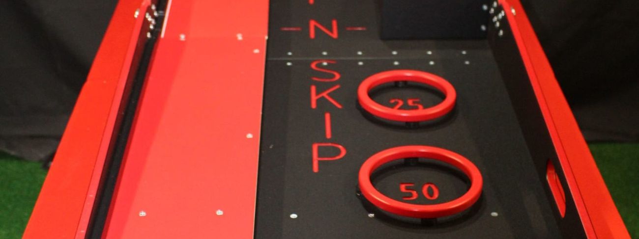 Red and black Whip n Skip tabletop game showing the U-turn channel and three scoring rings worth 25, 50 and 100 points