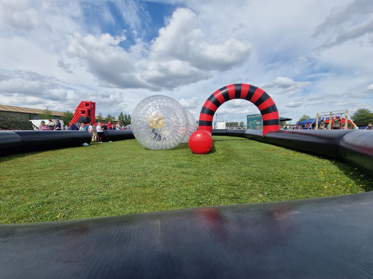 Two riders in transparent zorb balls racing along the inflatable track