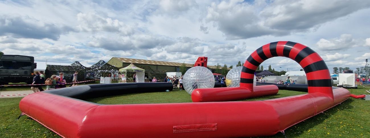 The inflatable zorb track with its striped start arch and two transparent zorb balls on the course